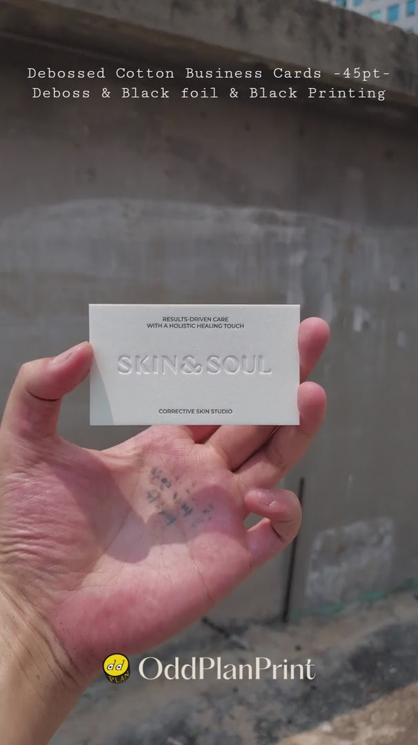 Elegant 45pt cotton debossed business cards with deboss, black foil and black printing made by OddPlanPrint.